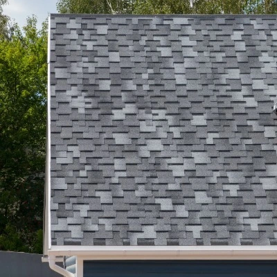 Gray architectural asphalt shingles showing dimensional texture and layered design on completed roof