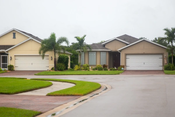 Row of residential homes with shingle roofs in a Central Florida neighborhood after a storm.