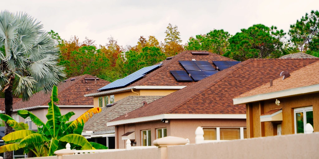 Florida homes with brown asphalt shingle roofs, one with rooftop solar panels